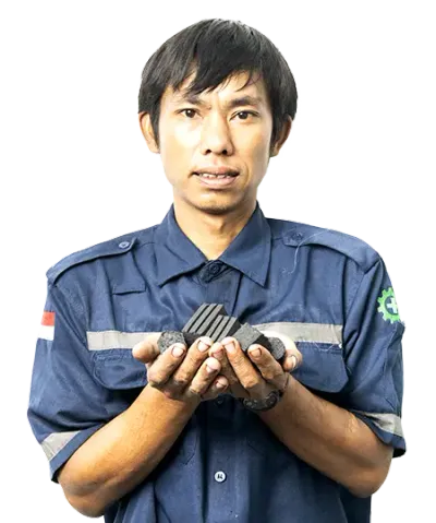 Factory worker holding premium coconut charcoal briquettes at Cocobriq production facility